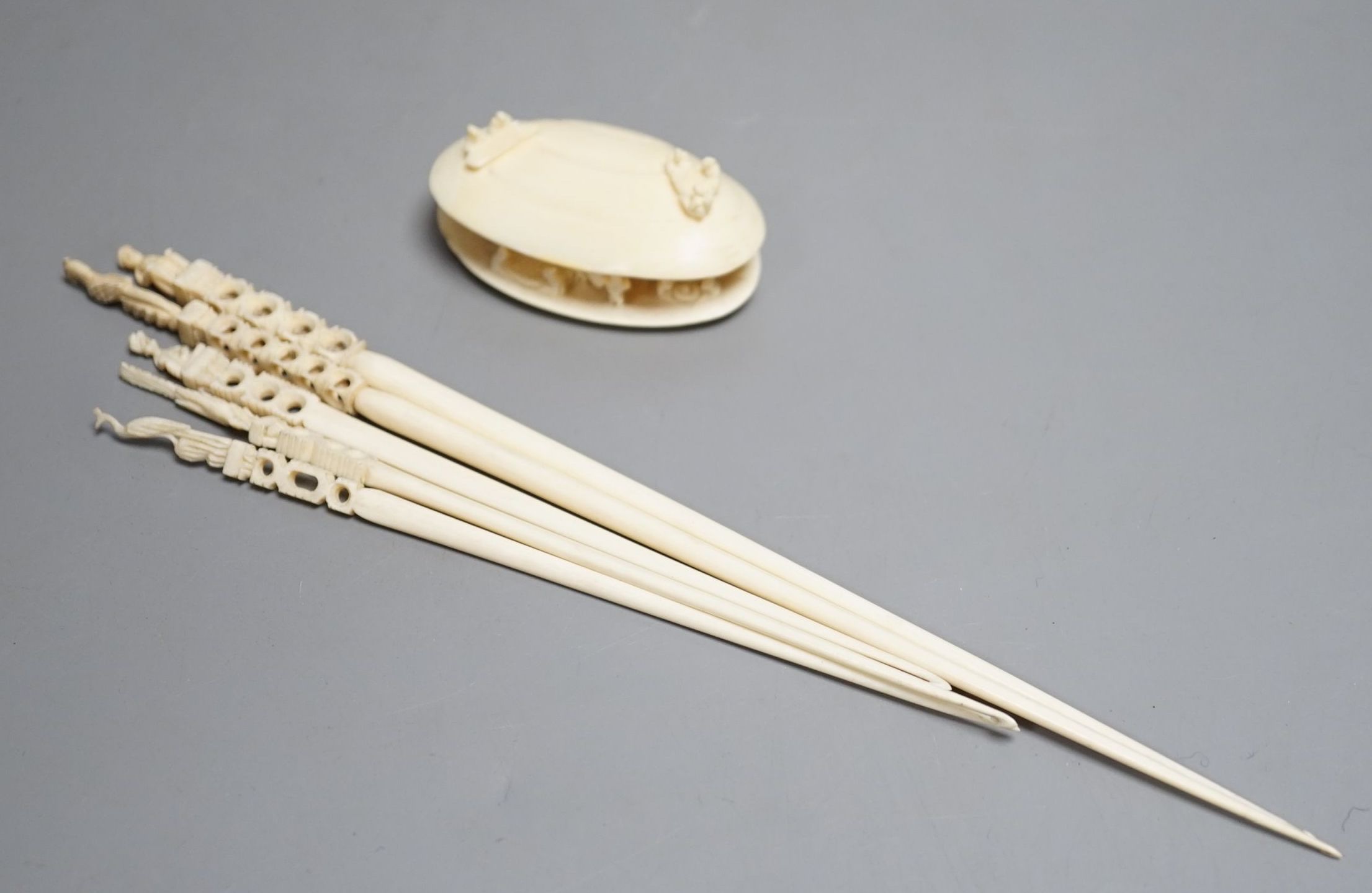 A Japanese ivory model of the clam's dream and five Indian ivory crochet hooks, late 19th/early 20th century